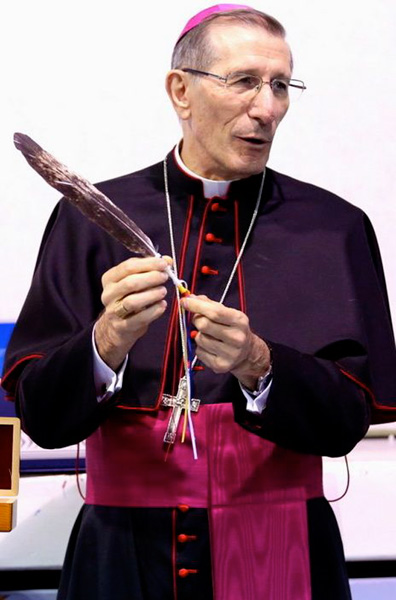 The Catholic Church's Vatican Ambassador to Canada, Luigi Bonazzi, holds an eagle feather given to him by the Muskeg Lake Cree Nation for his initiative to meet with the Cree peoples of the Treaty 6 Territory and the Prince Albert Catholic Diocese.