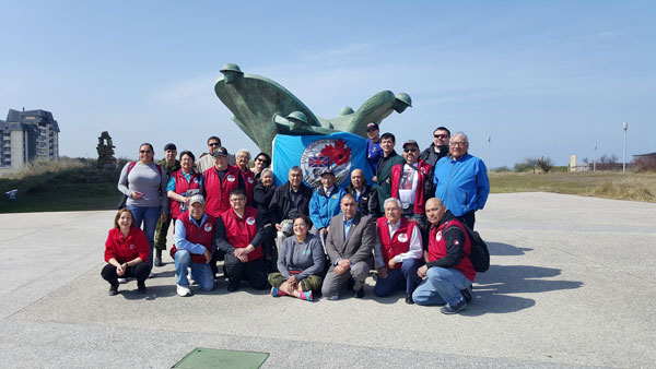 The touring group stopped for a photo at this monument at Juno Beach. 
